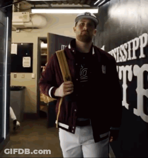 Man In Maroon Jacket And White Pants Walking Past Mississippi GIF