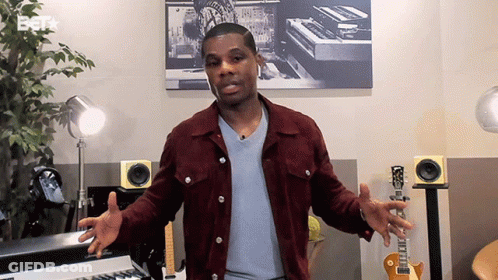 Man In Maroon Jacket Standing In Front Of Keyboard And Guitar GIF