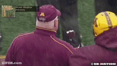 Man In Maroon Jacket With Letter A Eating Football GIF