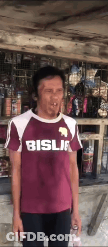 Man In Maroon Shirt Making Funny Face In Front Of Store GIF