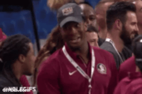 Man In Maroon Shirt Talking To Woman In Crowd GIF