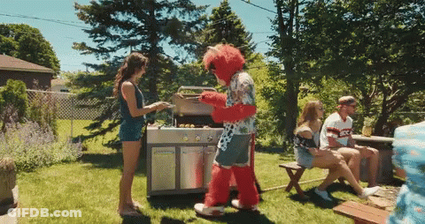 Man In Mascot Costume Standing Next To Grill GIF