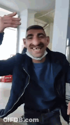 Man In Mask And Blue Shirt Making Funny Face GIF