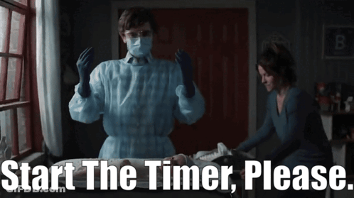 Man In Mask And Gloves Next To Woman Saying Start The Timer Please GIF