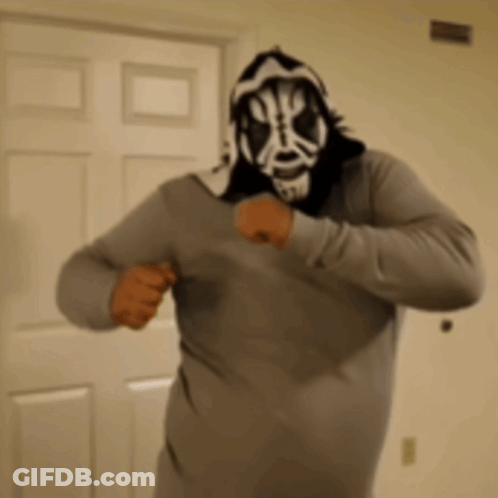 Man In Mask And Hoodie Standing In Front Of Door GIF