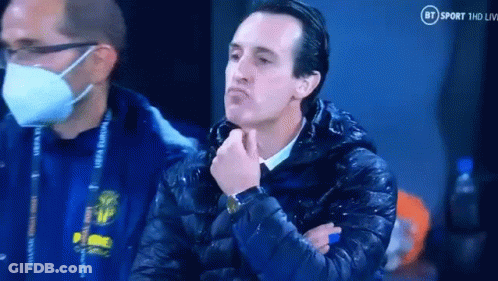 Man In Mask And Jacket Sitting With Hand On Chin GIF