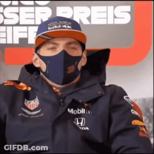Man In Mask And Red Bull Hat Sitting In Front Of Preis Sign GIF