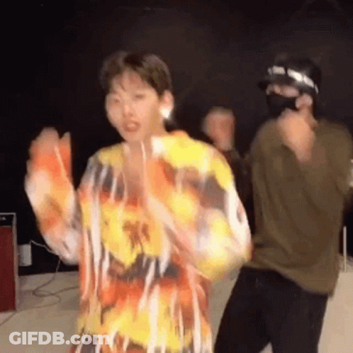 Man In Mask Dancing With Woman In Colorful Shirt GIF