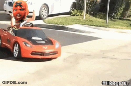 Man In Mask Driving Toy Car On Street GIF