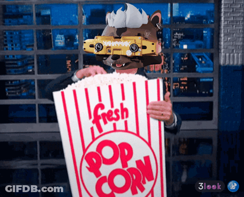 Man In Mask Holding Bag Of Popcorn GIF