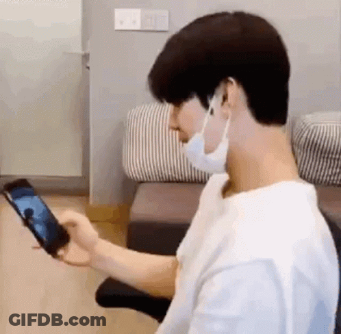 Man In Mask Holding Cell Phone GIF