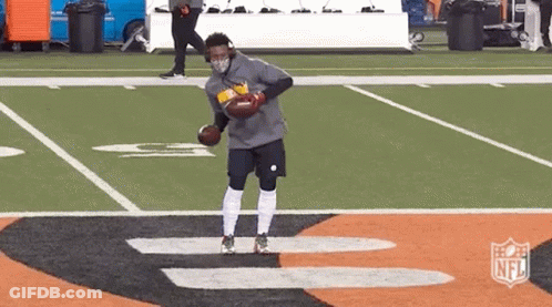Man In Mask Holding Football On Field GIF