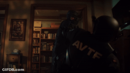 Man In Mask Holding Gun With AVTF On Shirt GIF