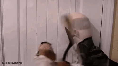 Man In Mask Holding Scissors In Front Of Door GIF