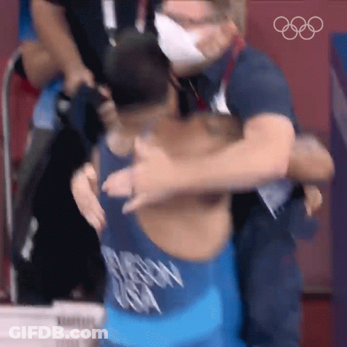 Man In Mask Hugging Wrestler With Chicago Shirt GIF