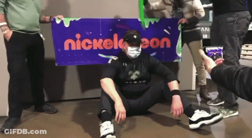 Man In Mask In Front Of Nickelodeon Sign GIF