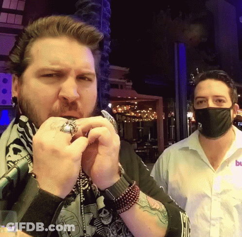 Man In Mask Next To Man In Bu Shirt GIF