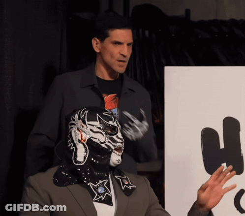 Man In Mask Next To Man In Suit GIF