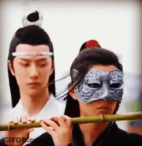 Man In Mask Playing Flute GIF