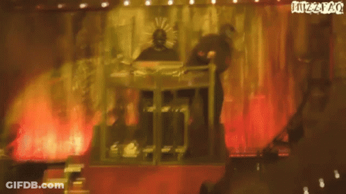 Man In Mask Playing Keyboard On Stage With Juzzpao Sign GIF