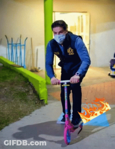 Man In Mask Riding Pink Scooter GIF