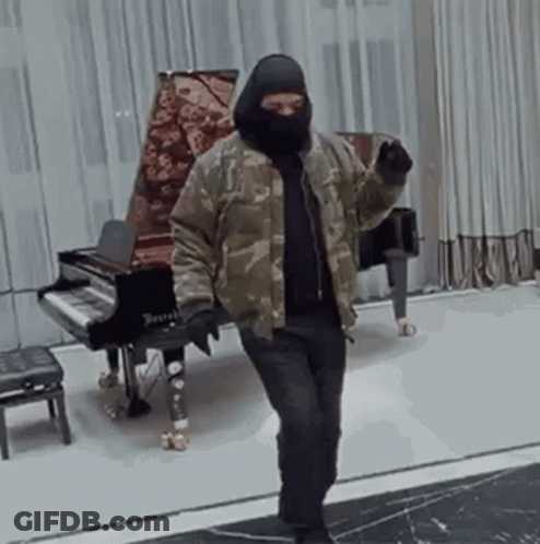 Man In Mask Standing At Piano GIF
