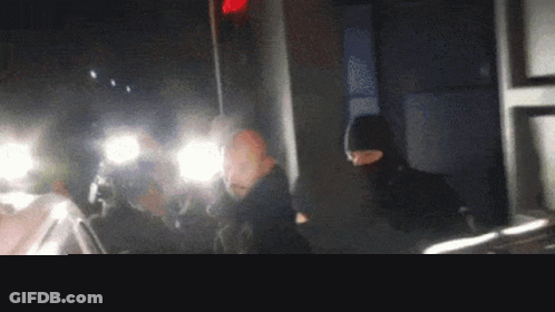 Man In Mask Standing In Dark Room GIF