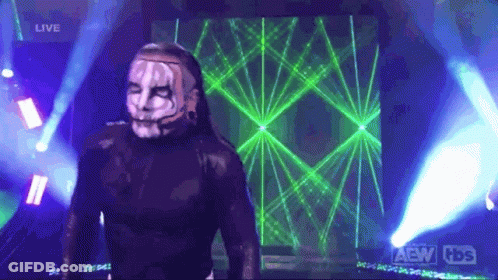 Man In Mask Standing In Front Of AEW Screen GIF