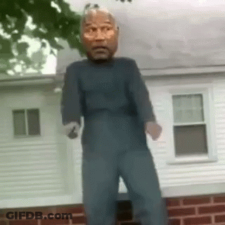 Man In Mask Standing In Front Of Brick Building GIF