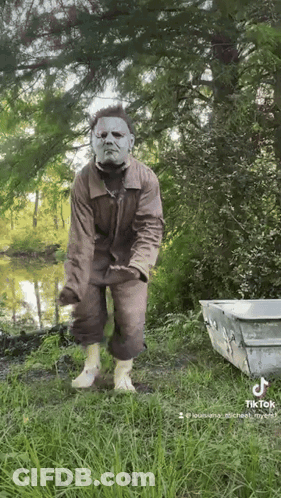 Man In Mask Standing Near Lake GIF