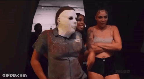 Man In Mask Standing Next To Two Women In Underwear GIF