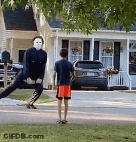 Man In Mask Standing On One Leg In Front Of House GIF