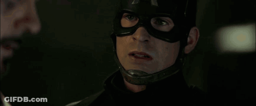 Man In Mask Talking To Another Man In Dark Room GIF