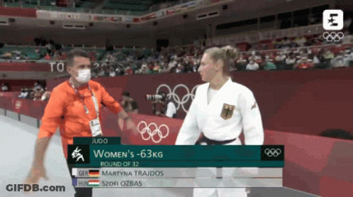 Man In Mask Talking To Woman In Judo Match GIF