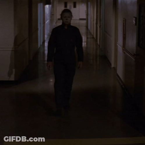 Man In Mask Walking Down Hallway With Knife GIF