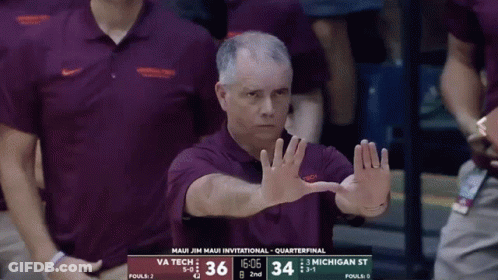Man In Maui Jim Maui Invitational Shirt In Front Of Scoreboard GIF