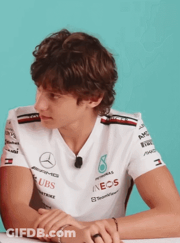 Man In Mercedes Shirt With Hands Folded At Desk GIF