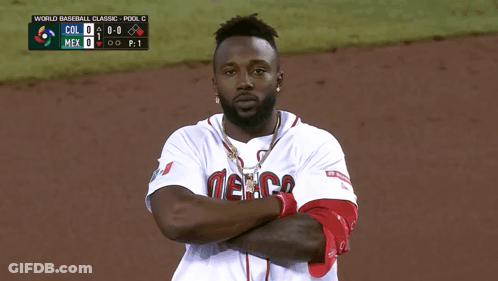 Man In Mexico Jersey With Arms Crossed In Front Of Scoreboard GIF