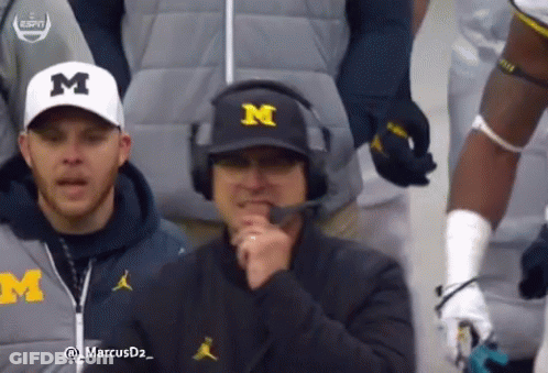 Man In Michigan Hat And Headphones Talking GIF