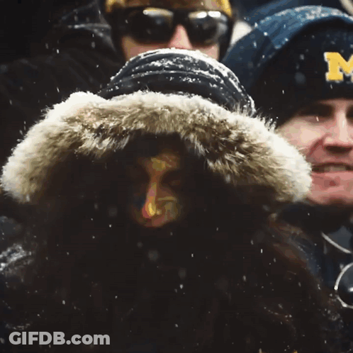 Man In Michigan Jacket Stands In Crowd GIF