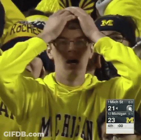 Man In Michigan Sweatshirt Holding Head GIF