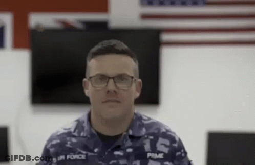 Man In Military Uniform And Glasses Looking At Camera GIF