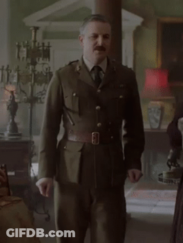 Man In Military Uniform And Tie Standing In Living Room GIF