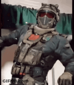 Man In Military Uniform Arms Outstretched In Front Of Green Curtain GIF