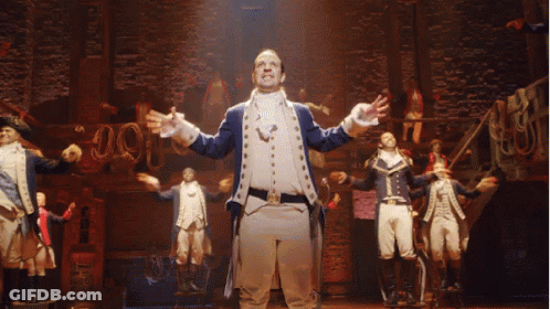 Man In Military Uniform Arms Outstretched On Stage GIF