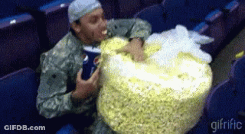 Man In Military Uniform Eating Large Bag Of Popcorn GIF