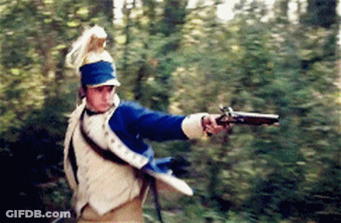 Man In Military Uniform Holding Gun In Woods GIF