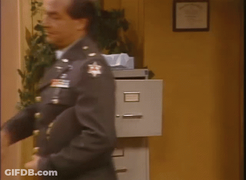 Man In Military Uniform Looking At Filing Cabinet GIF