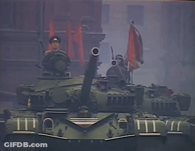 Man In Military Uniform On Tank Holding Gun GIF
