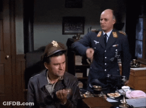 Man In Military Uniform Sitting At Desk While Another Man Laughs Behind Him GIF